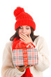Surprised young woman holding gift covering her mouth