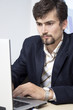 Casual looking businessman working on laptop