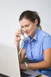 Business woman sitting in office with laptop