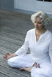 Seniorin macht Yoga auf der Terrasse