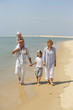Homme et femme marchant au bord de la mer avec des enfants
