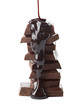 chocolate syrup being poured onto chocolate pieces isolated