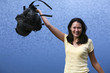 happy woman raising backpack on the background of sea