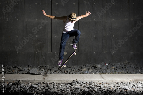 Photo: Skateboarder doing an ollie on walking path Skateboarder doing an ollie on walking path