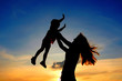 Silhouettes mother and child on sundown Silhouettes mother and child on sundown