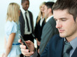 Foto: Young businessman sending a text in office Young businessman sending a text in office