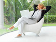 Middle age business woman working on laptop while looking throug