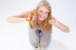 Happy blond woman with measuring tape on scale