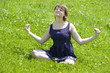 Junge Frau macht Joga in der Wiese