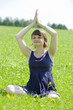Junge Frau macht Joga in der Wiese