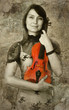 Beautiful female violinist playing violin on the grunge backgrou