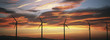 Silhouettes of wind turbines at sunset