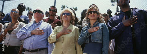 Photo: Crowd of people during national anthem, outdoors Crowd of people during national anthem, outdoors