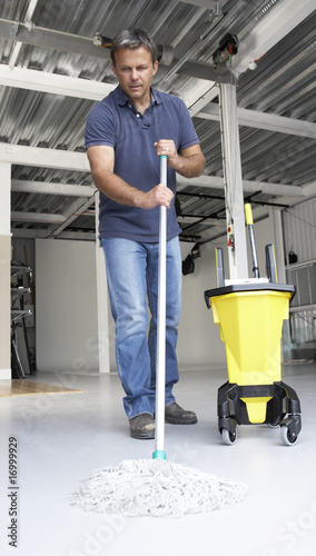 Photo: Cleaner mopping office floor Cleaner mopping office floor