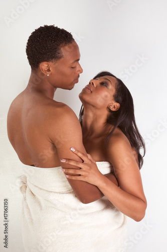 Photo: Ethnic young couple wrapped in white bath towel Ethnic young couple wrapped in white bath towel