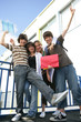 Adolescents souriants avec documents en levant les bras