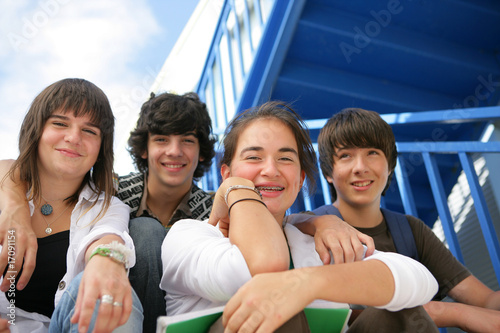 Adolescents souriants assis sur les marches avec documents