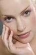 Young woman leaning hand on chin and looking at camera