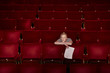 Young woman sitting in theatre stalls