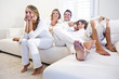 Family of four on the sofa watching television
