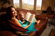 A stunning young woman reading on the couch