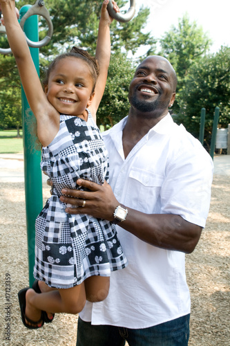 Photo: A father helps his daughter on the playground A father helps his daughter on the playground