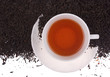 Cup of tea, tea leaves as background.