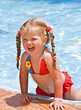 Child girl in red bikini near blue swimming pool. Child girl in red bikini near blue swimming pool.