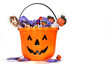 Jack-o-Lantern bucket filled with candies on white Jack-o-Lantern bucket filled with candies on white