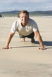 A happy man exercising on beach.