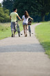 A young couple pushing bicycles