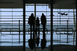 family looking to an airplane through the window