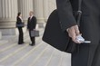 businessmen using cell phone and people talking in background