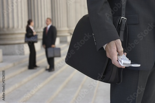 Foto: businessmen using cell phone and people talking in background businessmen using cell phone and people talking in background
