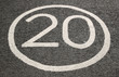 20 miles per hour sign on a tarmac road.