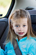 Little girl in a car seat looking at the viewer.