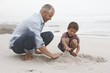 father playing with son on beach