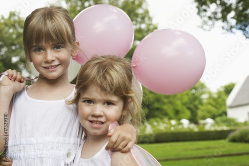 Foto: two girls with party balloons in garden two girls with party balloons in garden