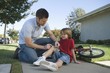 Father looking after son, bicycle laying on floor