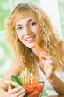 Young happy woman eating vegetables at home Young happy woman eating vegetables at home