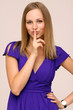 funny woman making hush sign standing indoors