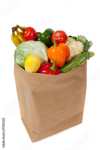Photo: grocery sack full of vegetables on a white background grocery sack full of vegetables on a white background