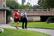 Coworkers engaged in conversation walking in urban park.