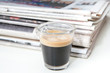 Espresso neben Zeitungen