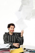 Man sitting at desk throwing up paperwork