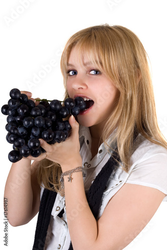 Photo: Portrait of the girl eating grapes. Isolated Portrait of the girl eating grapes. Isolated