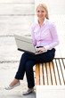 Photo: Woman using laptop outdoors Woman using laptop outdoors
