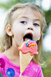 Little girl with sucker in the shape of an ice cream cone.