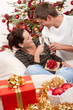 Young couple with champagne in front of Christmas tree