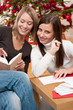 Two young women writing Christmas cards